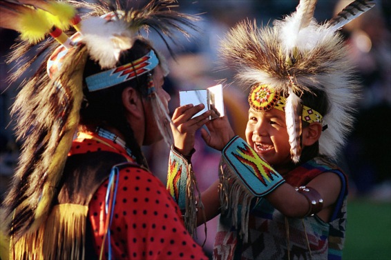 Wayne Smartlowit, left, gets a look at his reflection as his son, Kevin, 7, holds a mirror at a Pow Wow in Auburn, Wash., put on by the Muckleshoot tribe. (Photo by Troy Wayrynen)
